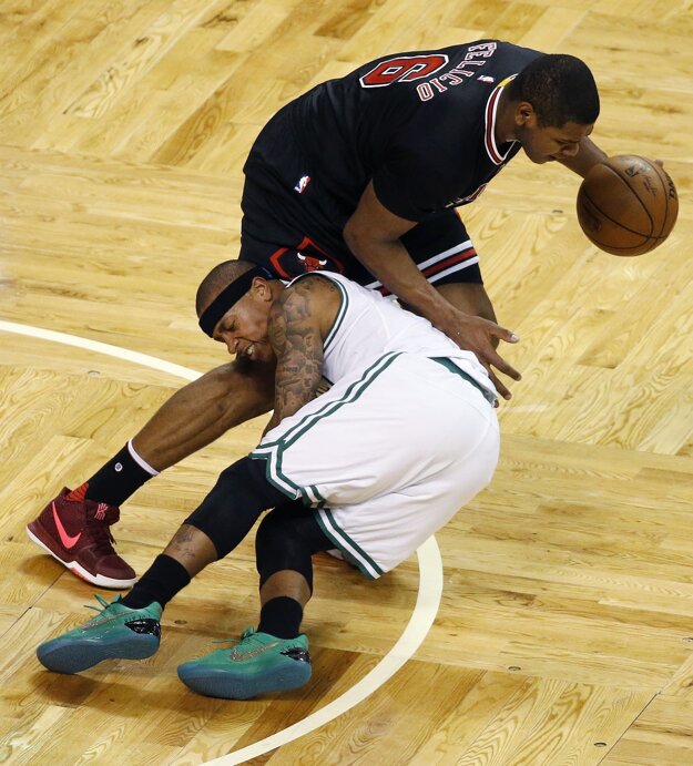 Isaiah Thomas z Bostonu (v bielom) padá v súboji s Cristianom Feliciom z Chicaga Bulls.
