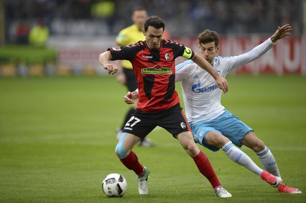 Nicolas Hoefler (vľavo) z Freiburgu si kryje loptu pred Leonom Goretzkom zo Schalke.