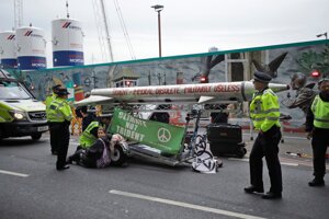 Policajti zastavujú demonštrantov počas demonštrácie Extinction Rebellion v centrálnom Londýne 7. októbra 2019. Klimatickí aktivisti blokovali cestu vedúcu do britského parlamentu v dopravnej špičke. Tisícky ľudí sa v nedeľu zúčastnili na otvorení protestov, ktoré iniciatíva Extinction Rebellion počas najbližších dvoch týždňov plánuje uskutočniť v 60 mestách po celom svete.