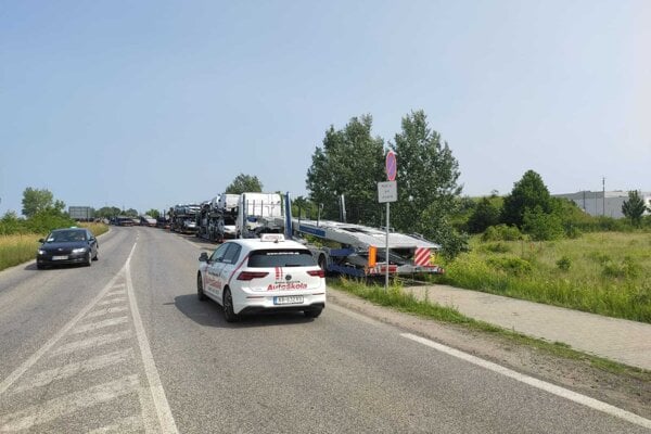 Na chodníku vedúcom do automobilky parkujú kamióny.