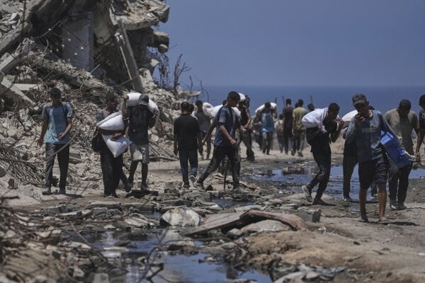 Obyvatelia Gaza City si nesú múku, doručenú v rámci humanitárnej pomoci. 