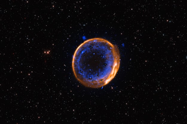 Na snímke je pozostatok supernovy SNR 0509-67,5. Ide o rozpínajúce sa pozostatky hviezdy, ktorá pred stovkami rokov explodovala pri dvojitej detonácii. Je to prvý fotografický dôkaz, že hviezdy môžu zaniknúť dvoma výbuchmi. (zdroj: ESO/P. Das et al. Background stars (Hubble): K. Noll et al.)
