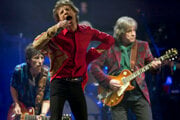 Mick Jagger (v strede), Ronnie Wood (vľavo) a Mick Taylor z britskej rockovej kapely The Rolling Stones vystupujú na hlavnom pódiu Pyramid na festivale Glastonbury v Anglicku, 29. júna 2013.
