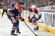 Juraj Slafkovský (Montreal) a Evan Bouchard (Edmonton) v súboji pri mantineli.