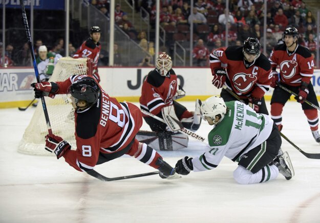 Pred bránou New Jersey padá hráč Devils Beau Bennett (vľavo) po súboji s Curtisom McKenziem z Dallasu.