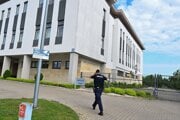 Policajt kráča k budove prokuratúry v meste Grójec počas predvedenia 60-ročného kňaza z Mazovského vojvodstva.