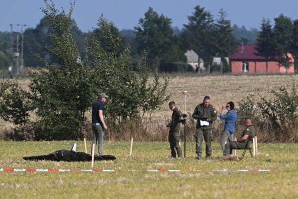 Poľské bezpečnostné zložky zaisťujú trosky zostreleného dronu.