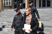 Polícia odvádza Filipa Okoličányho do väzby.