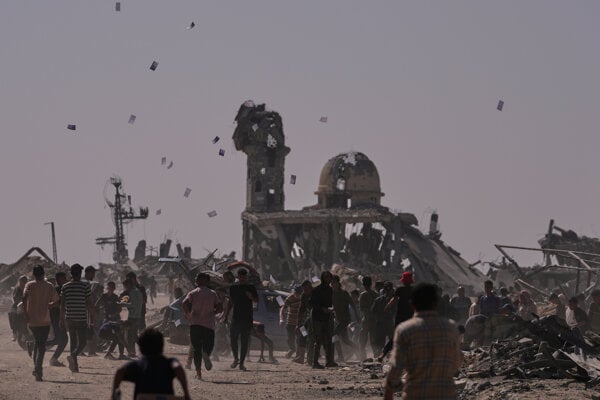 Palestínčania zbierajú letáky zhadzované izraelským dronom varujúce ľudí, aby sa nevzdiaľovali z tzv. žltej zóny v meste Chán Júnis, na juhu Pásma Gazy 20. októbra 2025.