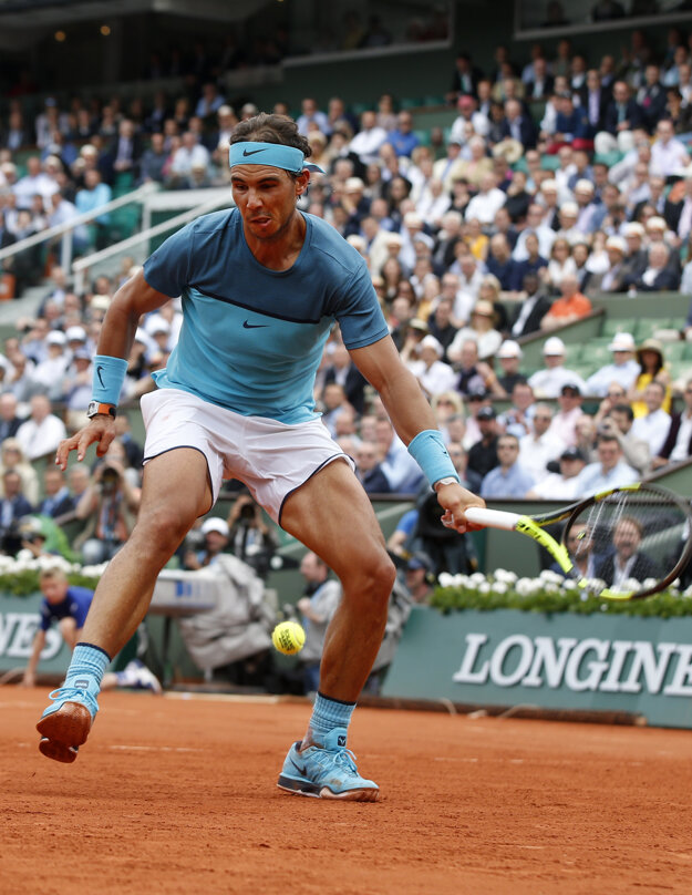 Rafael Nadal odvracia loptičku úder pomedzi nohy.