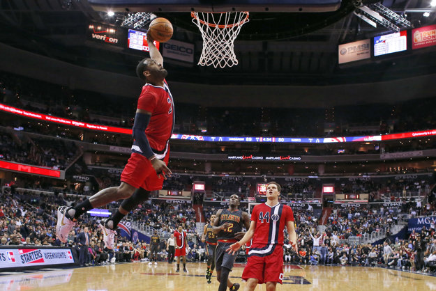 John Wall z Washingtonu (vľavo) zakončuje na kôš v zápase proti Atlante.