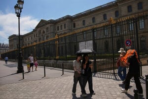 Ľudia si chránia hlavy počas horúčav v Paríži