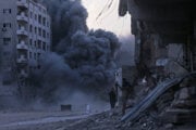 Palestínčania sa schovávajú pri explózii počas izraelského leteckého útoku na budovu v meste Gaza.