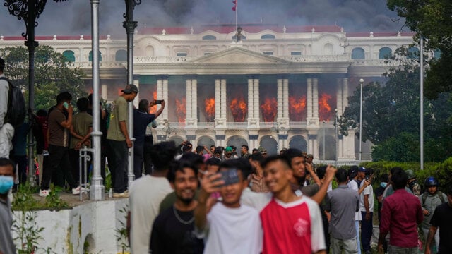 Mladí demonštranti sa fotia pred vládnym komplexom Singha Durbar v hlavnom meste Nepálu Káthmandú, ktorý zapálili.