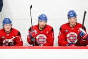 Juraj Slafkovský (vpravo) a jeho spoluhráči Nick Suzuki (uprostred) a Cole Caufield sedia na striedačke počas tréningového zápasu.