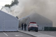 Policajti stoja na ulici, zatiaľ čo sa lokalizuje požiar v tábore pred srbským parlamentom v Belehrade.