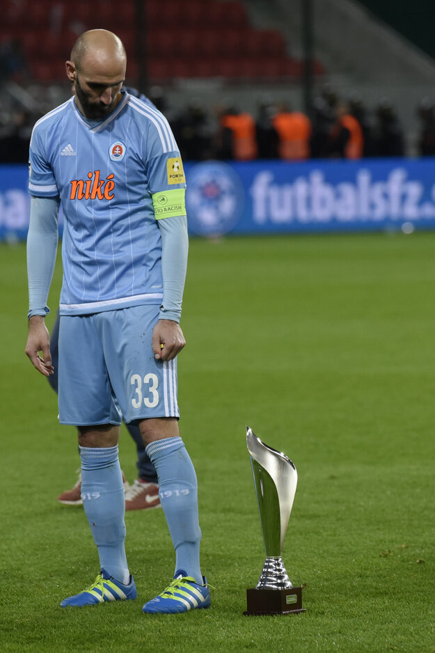 Róbert Vittek sa pozerá na pohár za druhé miesto. Slovanu v minulej sezóne ušlo prvenstvo v Slovnaft Cupe tesne.