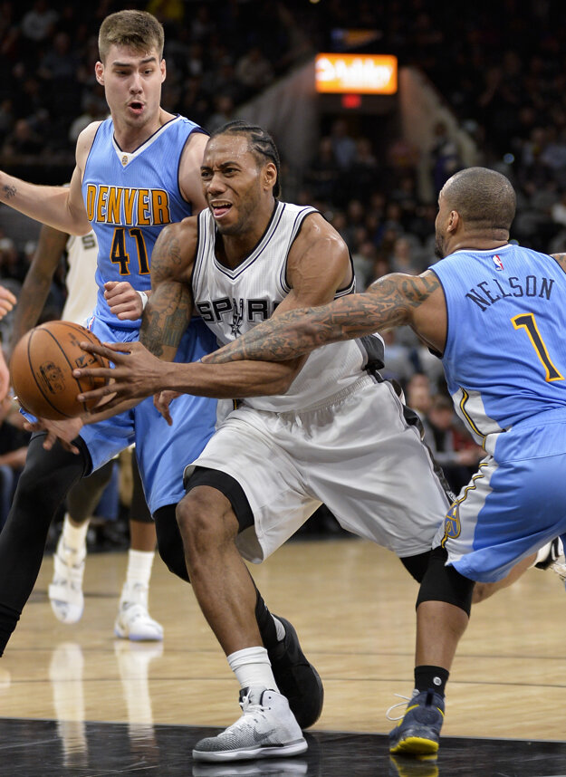 Kawhi Leonard (v strede) sa pokúša preniknúť cez dvoch hráčov Denveru.