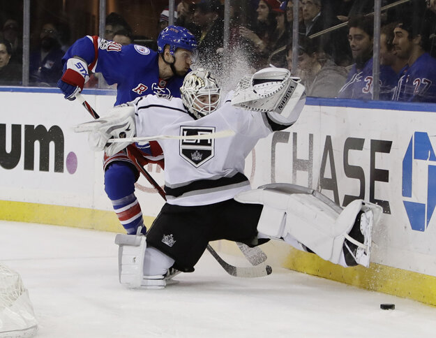 Brankár Los Angeles Jeff Zatkoff padá za bránou po súboji s Michaelom Grabnerom.