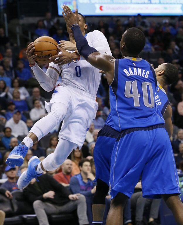 Russell Westbrook (vľavo) sa snaží presadiť cez dvoch basketbalistov súpera.