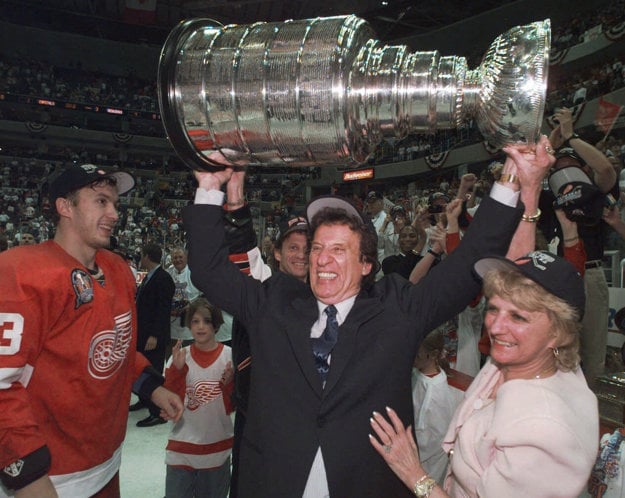 Na snímke zo 17. júna 1998 Mike Ilitch dvíha nad hlavu Stanleyho pohár. Po jeho pravici stojí Igor Larionov.