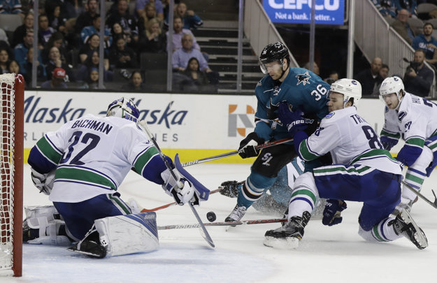 Jannik Hansen (s číslom 36) zo San Jose sa pokúša presadiť pred bránou Vancouveru.