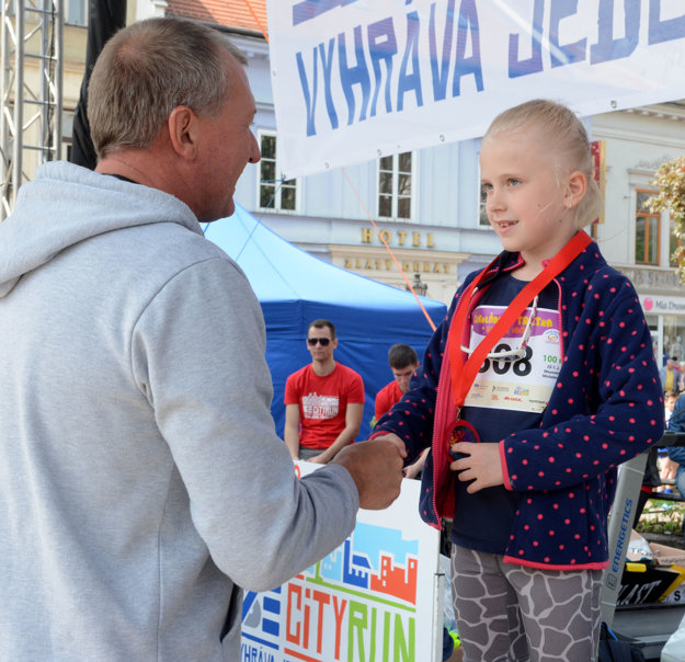 Igor Kováč. Dekoruje víťazku behu na 100 m Nelku Kucákovú.