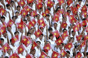Účastníci s vietnamskými vlajkami pochodujú počas slávnostnej prehliadky v Hočiminovom meste (bývalý Saigon) pri príležitosti 40. výročia ukončenia vietnamskej vojny 30. apríla 2015.