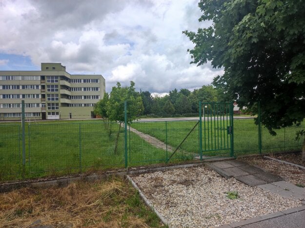 Pozemok pri škole na Zdravotníckej ulici, ktorý je súčasťou výmeny za penzión v Radave. Cez bránku prechádzajú študenti po Jarkovej ulici do druhej budovy školy na Slovenskej ulici. (zdroj: Anton Hrachovský )