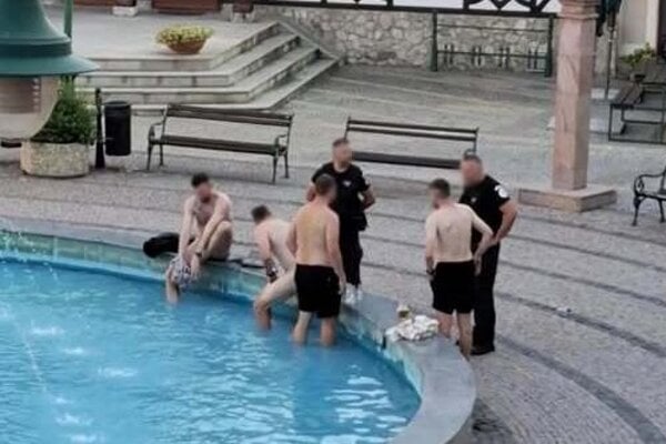 Partia Čechov kúpajúcich sa vo fontáne na Nádvorí Európy v Komárne. Medzi nimi aj jeden úplne nahý.