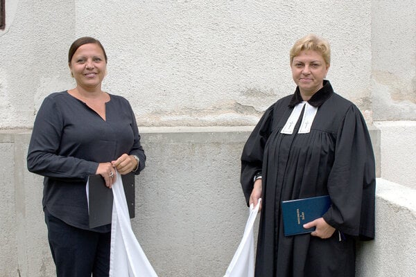 z Starostka Nižnej Boce Silvia Skusilová (vľavo) a farárka Viera Mosná (vpravo) pri odhaľovaní tabule Jánovi Lajčiakovi na kostole v Nižnej Boci.
