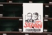 Plagát s portrétmi členov predchádzajúcej poľskej pravicovej vlády, bývalého ministra vnútra Mariusza Kaminského a bývalého námestníka ministra vnútra Macieja Wasika, ktorí boli odsúdení za zneužitie moci a chodili do parlamentu, aj keď už nemali mandát.