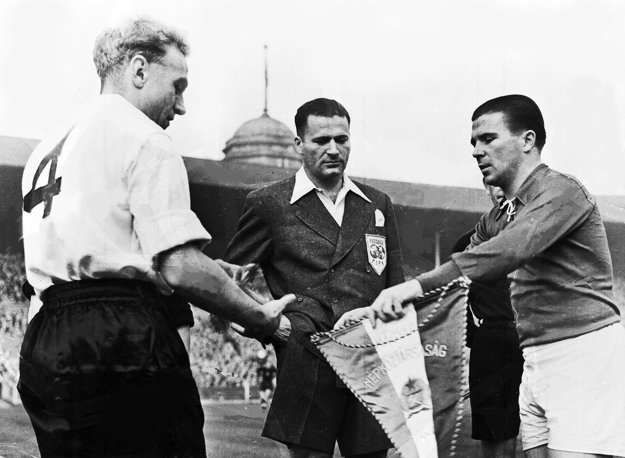 Na snímke z 25. novembra 1953 si Ferenc Puskás (vpravo) vymieňa vlajku s kapitánom Anglicka Billym Wrightom pred medzištátnym stretnutím vo Wembley.