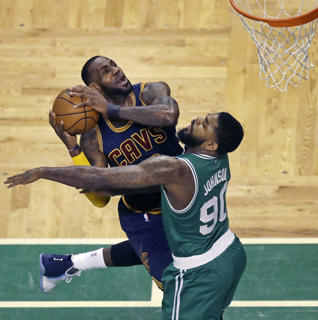 LeBron James (vľavo) z Clevelandu sa prediera do zakončenia cez Amira Johnsona.