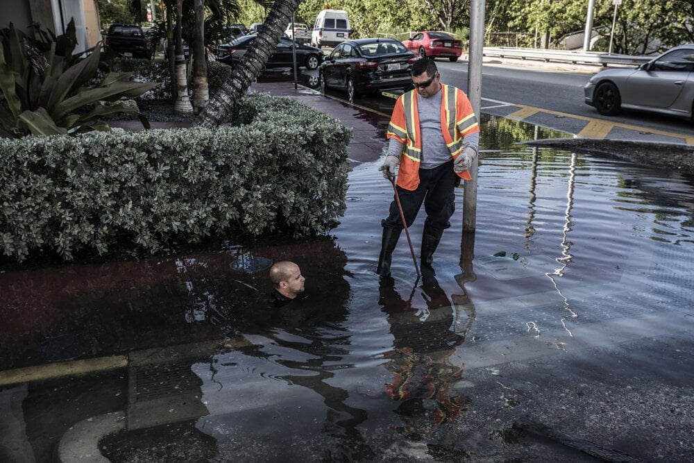 Miami. Obrovský príliv na Miami Beach. Voda preniká do ulíc cez slabo udržiavanú hrádzu v Indian Creek a cez odvodňovací systém.
Pracovníci kontrolujú, či odvodňovací systém nie je zablokovaný.