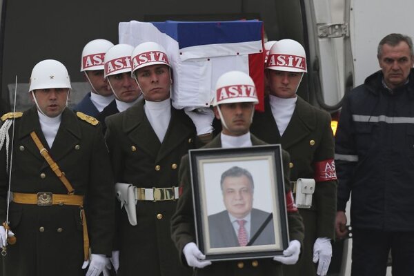 Členovia čestnej stráže nesú fotografiu a truhlu s pozostatkami ruského veľvyslanca v Turecku Andreja Karlova počas ceremoniálu na letisku 20. decembra 2016 v Ankare. 