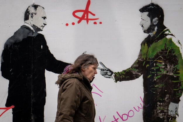 Žena prechádza okolo graffiti s vyobrazením ruského prezidenta Vladimira Putina a ukrajinského prezidenta Volodymyra Zelenského v centre Londýna. (zdroj: SITA/AP)