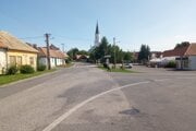 Cesta prechádza cez stred Bátoviec, napravo je námestie.
