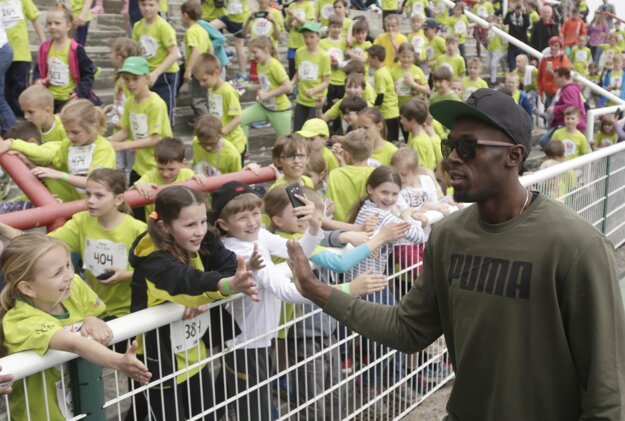 Jamajský šprintér Usain Bolt sa zdraví s deťmi počas detského atletického mítingu Čokoládová tretra v Prahe.