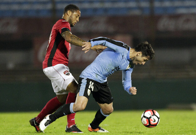 Shahdon Winchester (vľavo) sa snaží vziať loptu Uruguajčanovi Nicolasovi Lodeirovi.