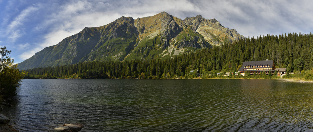 Panoráma časti hrebeňa Bášt nad hladinou Popradského plesa, vpravo Horský hotel Popradské pleso, ďalej vľavo Majláthova chata.