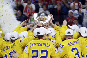 Hokejisti Švédska dvíhajú nad hlavu majstrovskú trofej.