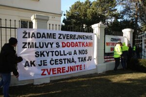 Transparenty na plote Úradu vlády SR počas protestného zhromaždenia Únie autodopravcov Slovenska (UNAS) za otvorenie zmluvy a dodatkov na mýtnom systéme a vyvodenia trestnoprávnej zodpovednosti na generálnej prokuratúre.