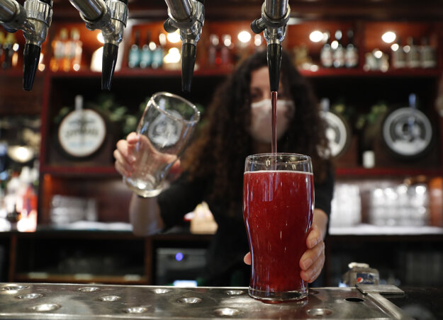 Čašníčka čapuje prvý alkoholický nápoj - cider - v pube Shakespeare's Head v Londýne, v ktorom po prvý raz od posledného lockdownu privítali zákazníkov vo vnútorných priestoroch