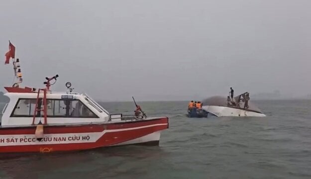 Snímka z videa poskytnutého QDND zobrazuje záchranu ľudí na prevrátenej turistickej lodi v zálive Ha Long. (zdroj: QDND)