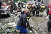 Záchranárka utešuje ženu, ktorá plače na mieste nočného ruského raketového útoku v Kyjeve.