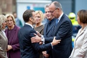 Francúzsky prezident Emmanuel Macron víta nemeckého kancelára Friedricha Merza pri jeho príchode počas Dňa nemeckej jednoty v Nemecku.