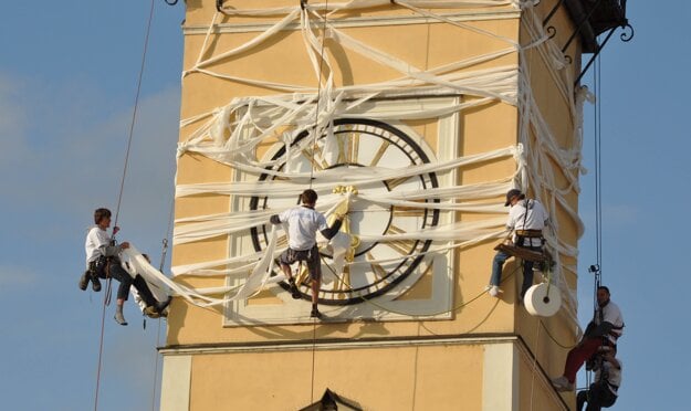 A group of men tries to achieve a record in wrapping Banská Bystrica’s clock tower in toilet paper on June 12, 2009, celebrating 180 years since the start of paper production at the SHP Harmanec company