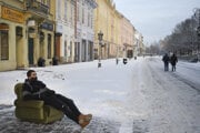 A man wearing a face covering sits in an armchair on the snow-covered Main Street in Košice on January 13, 2021.