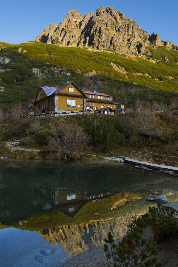 A mountain hut at the Green Mountain Lake in the Belianske Tatry mountain range and its reflection.